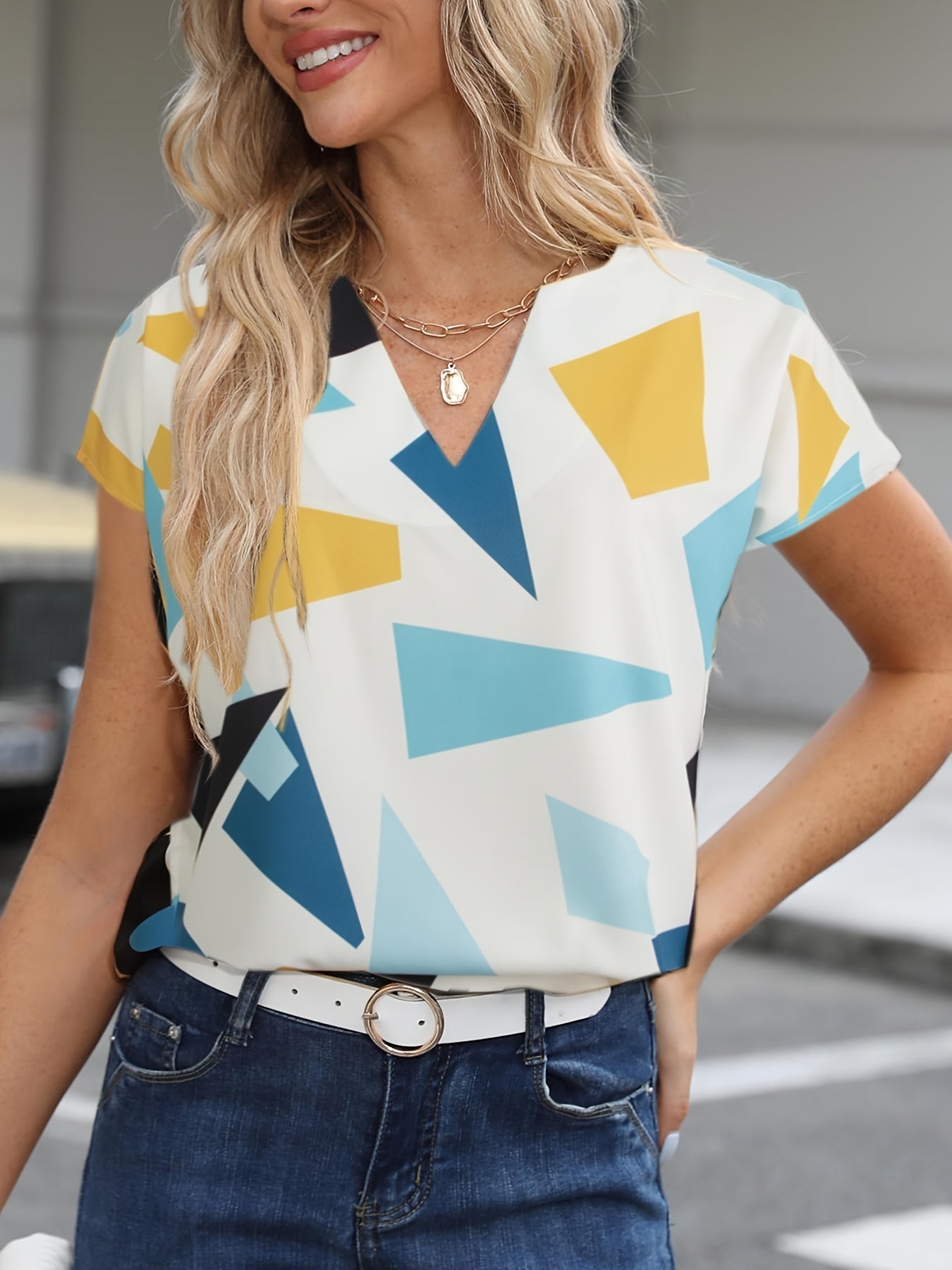 Damska vintageowa bluzka z geometrycznym wzorem i dekoltem w serek – elegancka moda letnia na co dzień i do biura