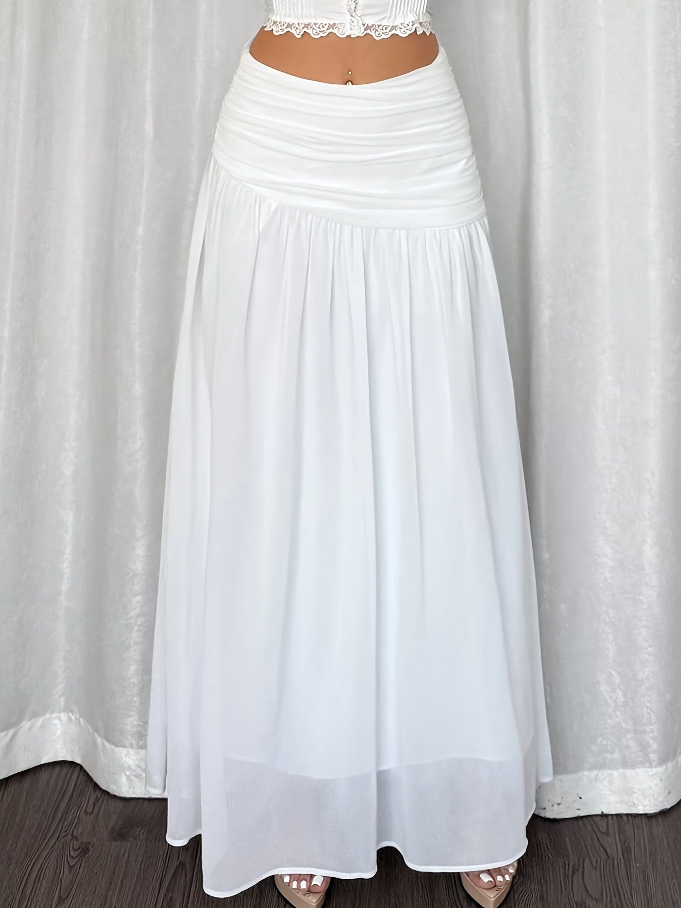 Gonna lunga da donna in stile resort sulla spiaggia, elegantemente drappeggiata, look estivo romantico
