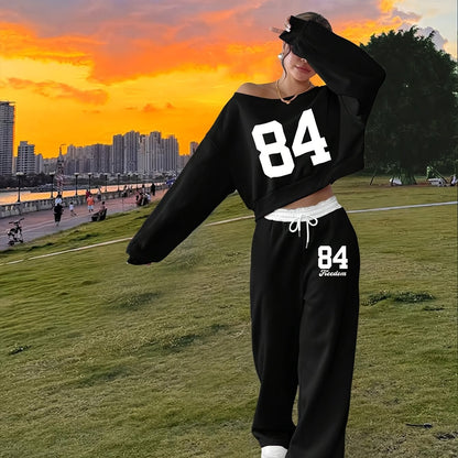 Tweedelige damesjoggingpak met crop top en wijde broek, grijs-zwart, print met nummer "84"