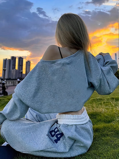 Tweedelige damesjoggingpak met crop top en wijde broek, grijs-zwart, print met nummer "84"