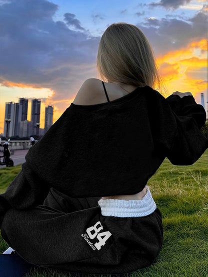 Tweedelige damesjoggingpak met crop top en wijde broek, grijs-zwart, print met nummer "84"