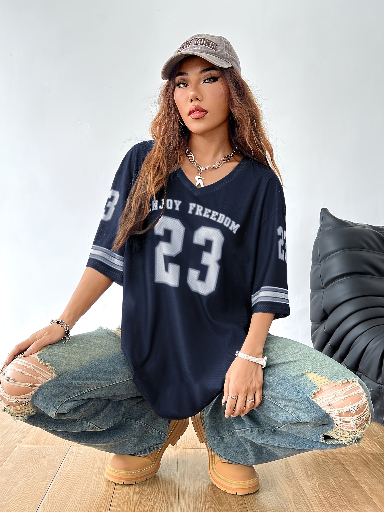 Damska oversize koszulka streetwearowa z nadrukiem numerów i luźne, postrzępione jeansy – swobodny miejski styl